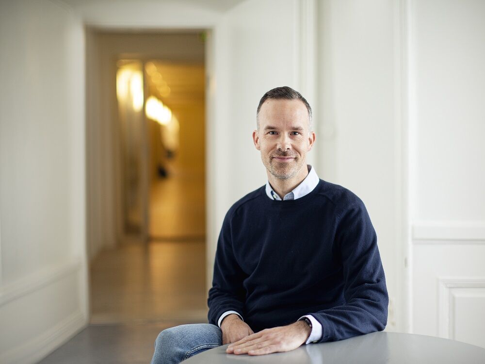 Daniel Karlsson AI-expert och projektledare i mörkblå tröja mot ljus kontorsbakgrund
